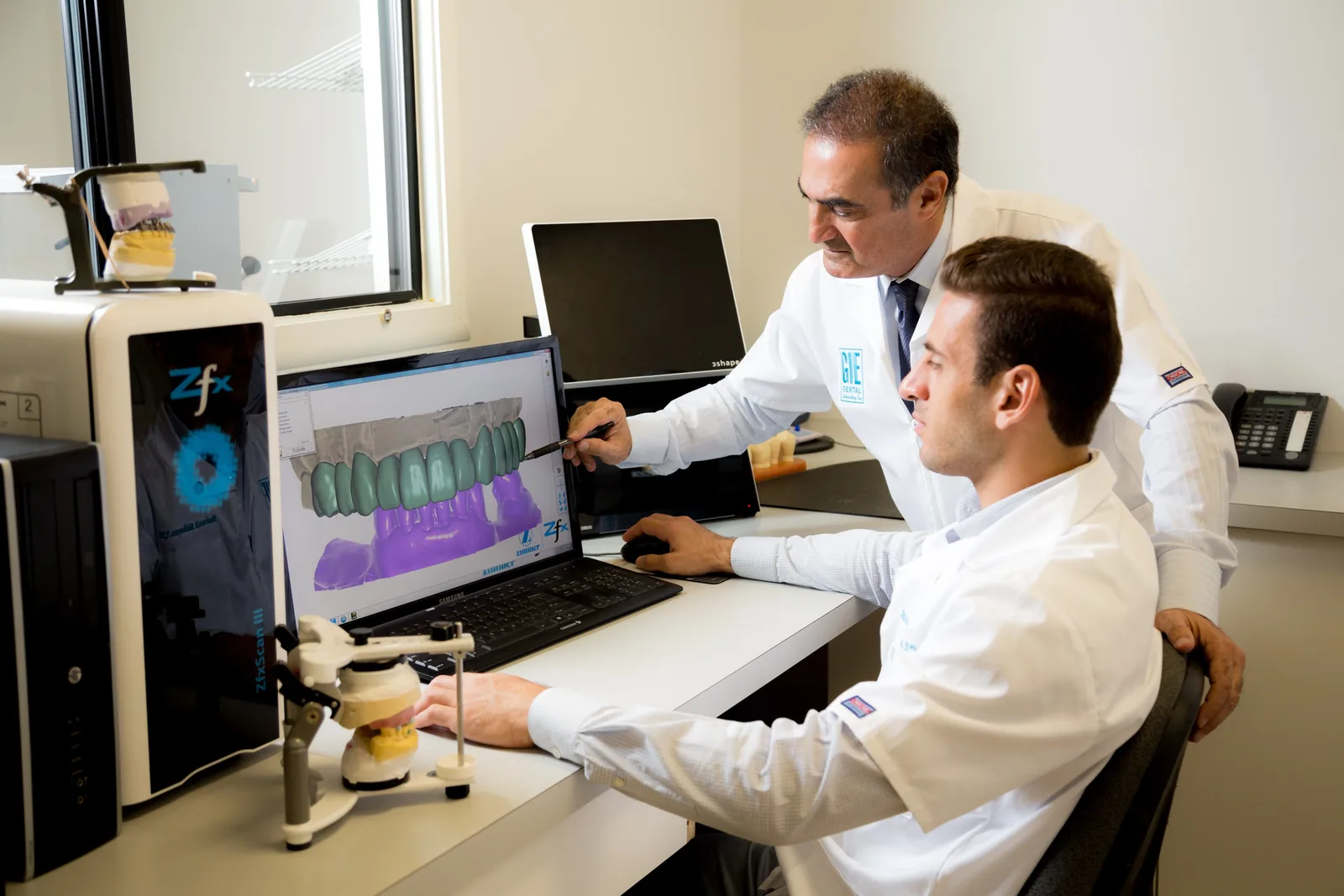 GIE Dental Lab technicians reviewing CAD design on 3Shape software